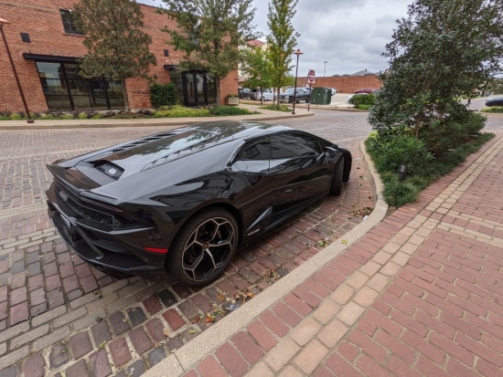 a black sports car parked on a brick road