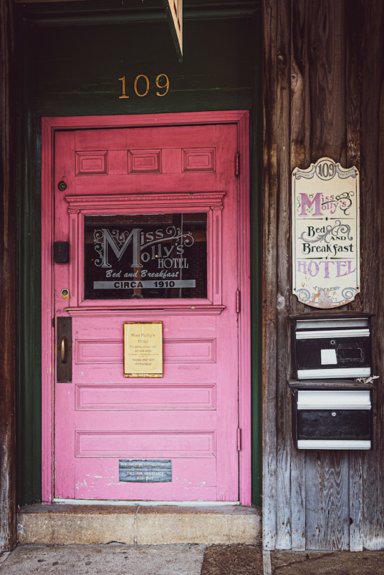 a pink door with a sign on the side