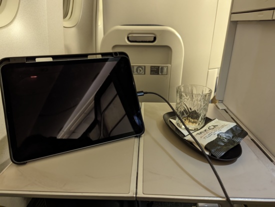 a tablet on a tray with a glass and a drink on it