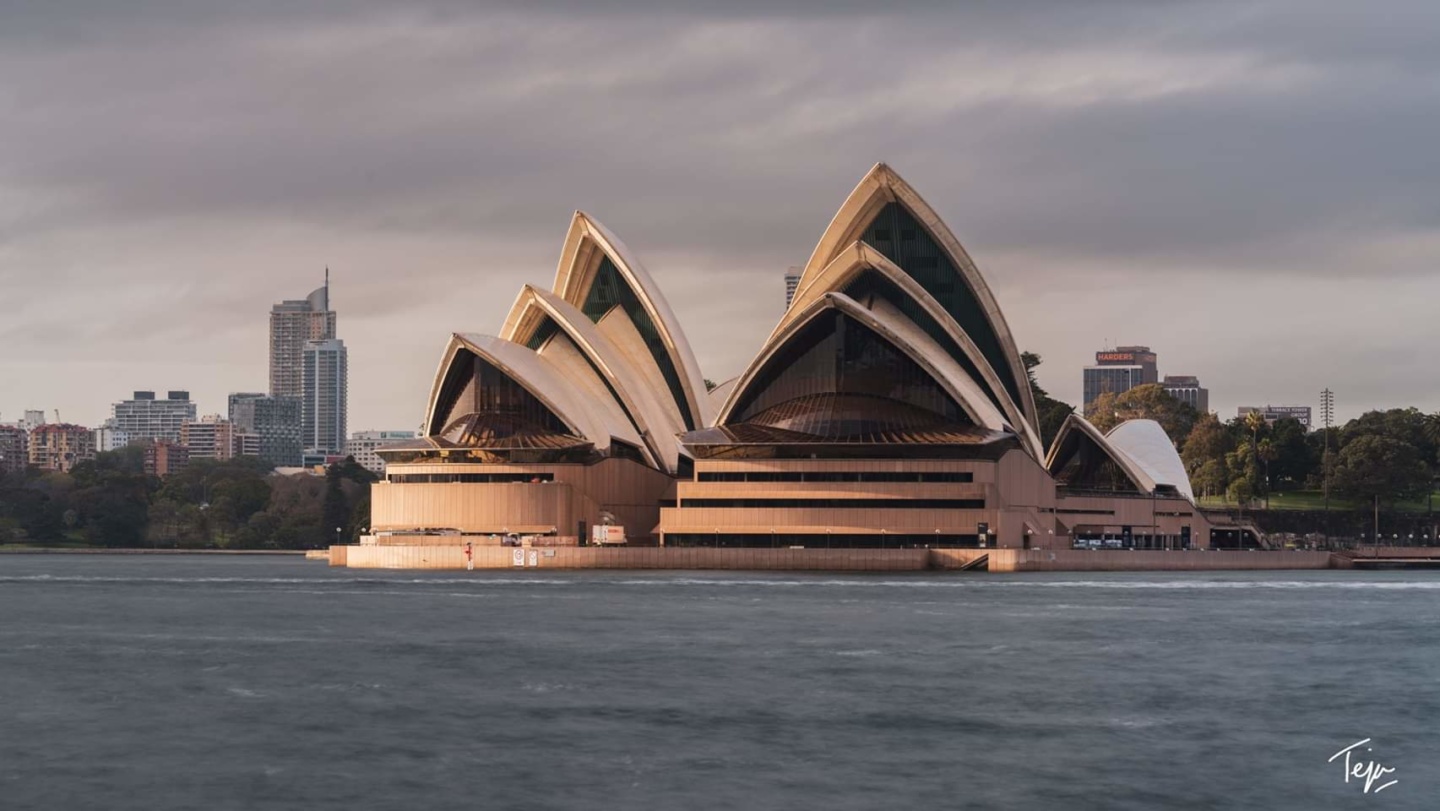 Sydney Opera House with pointed roof and a body of water