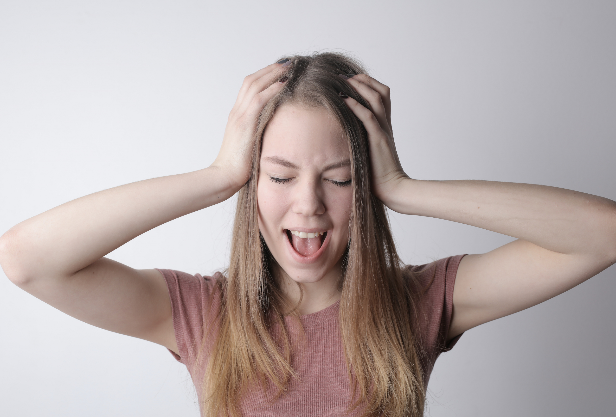 a woman holding her head with her mouth open
