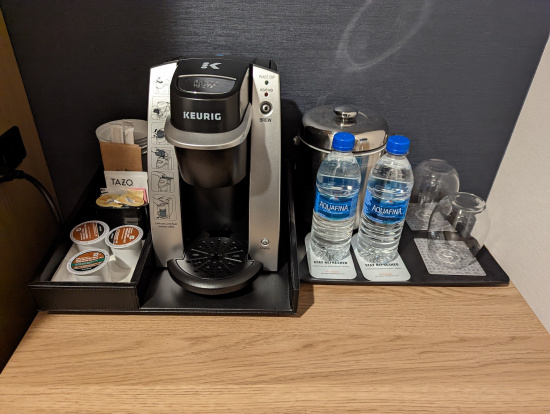 a coffee machine and water bottles on a tray