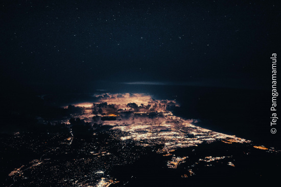 a city at night with clouds and stars