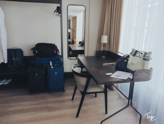 a room with a desk and luggage
