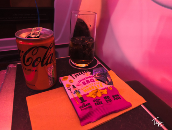 a can of soda and a bag of chips on a table