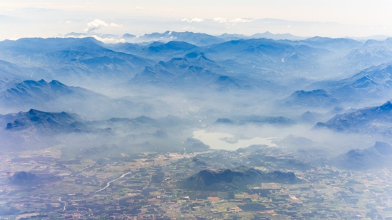 aerial view of a valley with mountains and clouds