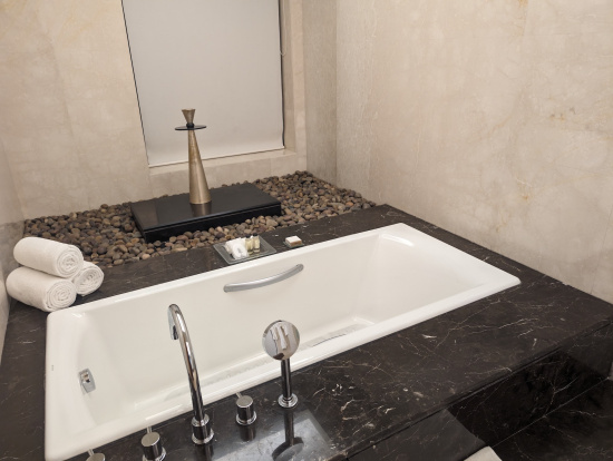 a bathtub and a black countertop with rocks