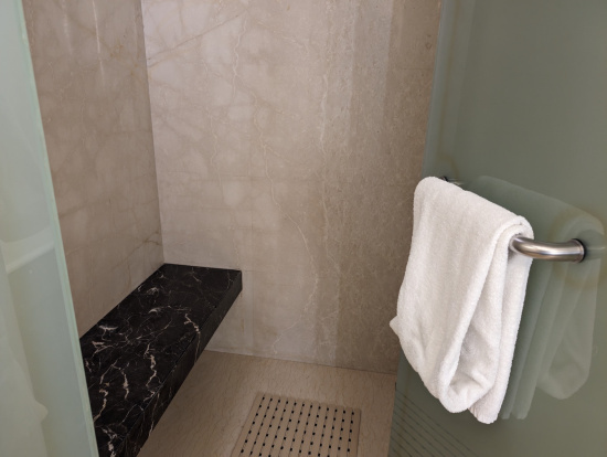 a white towel on a towel rack in a shower