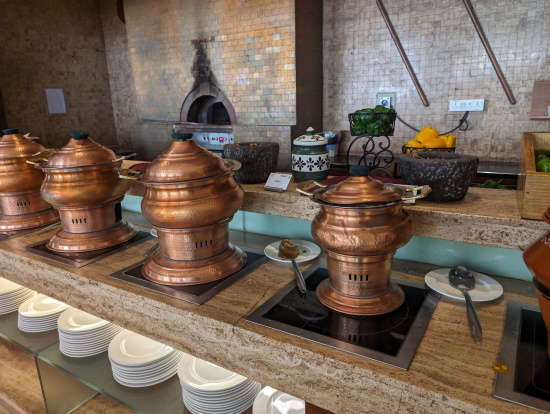 a row of copper pots on a counter