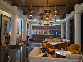 a lobby with a large chandelier and chairs