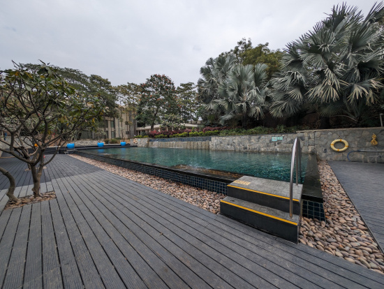 a pool with a wood deck and trees