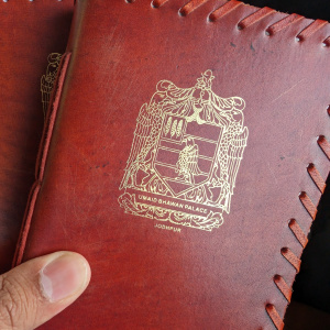 a hand holding a pair of red leather passport covers
