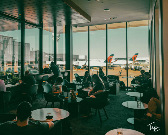 people sitting in a room with windows and airplanes in the background