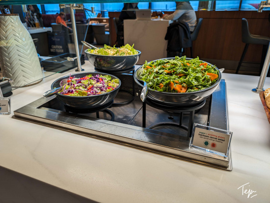 a group of bowls of salad on a counter