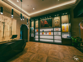 a room with a desk and art on shelves