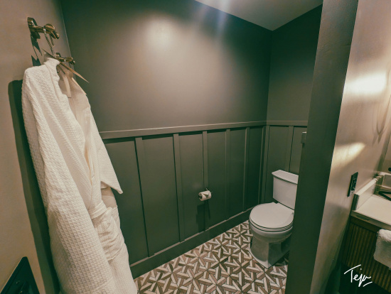 a bathroom with a white robe and a white towel on a hook