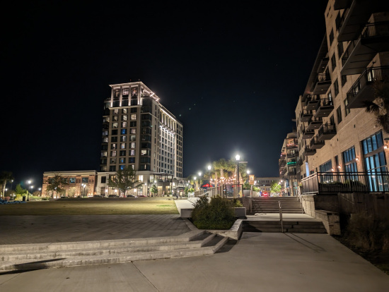 a city at night with buildings and stairs