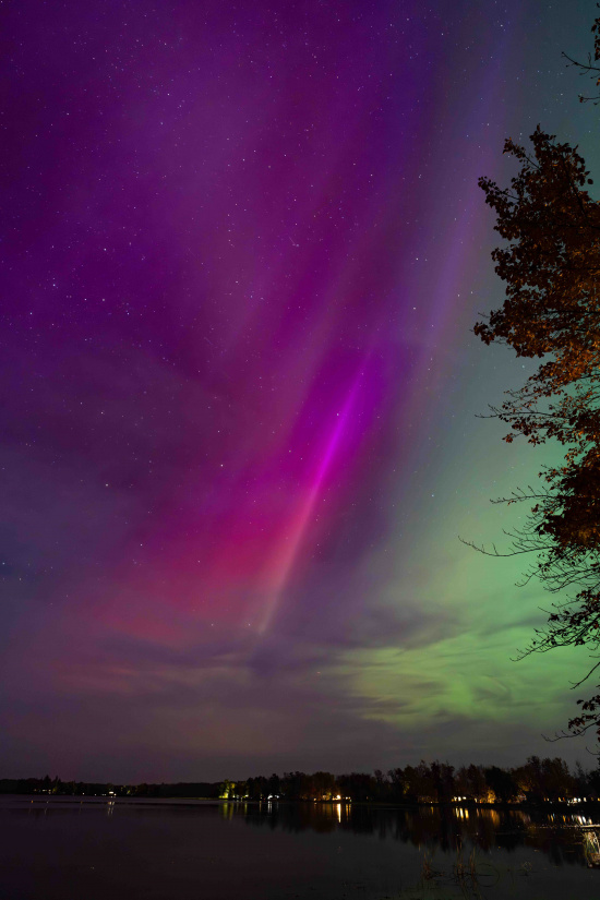 a purple and green sky with stars