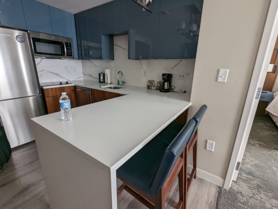 a kitchen with a white countertop and blue cabinets