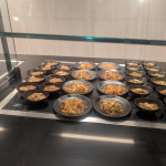 a group of black bowls of food on a counter