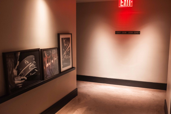 a room with a red exit sign and framed pictures