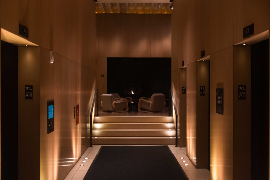 a hallway with stairs and chairs