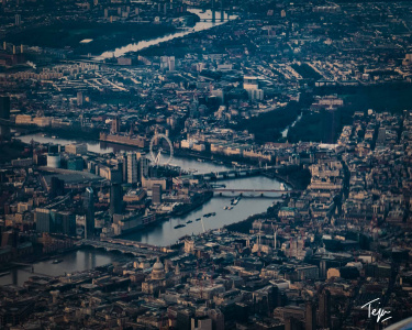 a city with a river and a ferris wheel