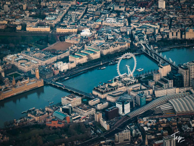 a city with a river and a ferris wheel