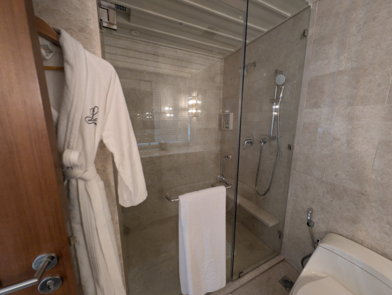 a bathroom with a glass shower door and a bathrobe