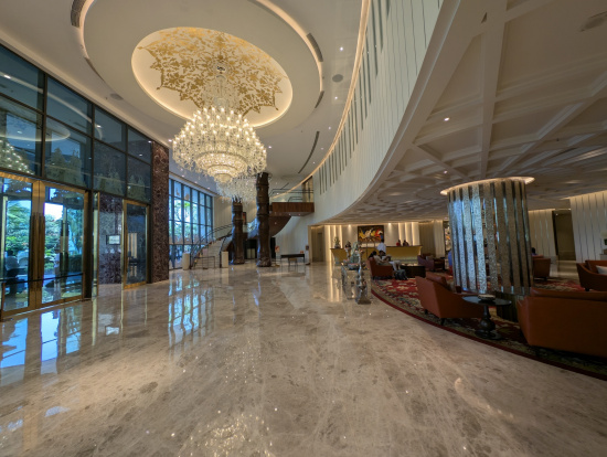 a large lobby with a chandelier and a large glass wall