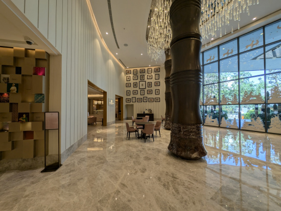 a large marble floor with a chandelier and a large column