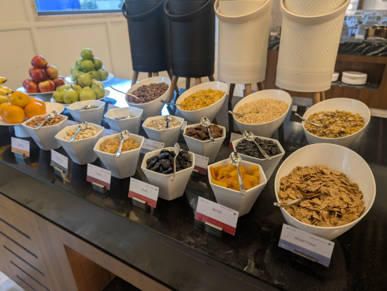 a table with bowls of cereal and fruits