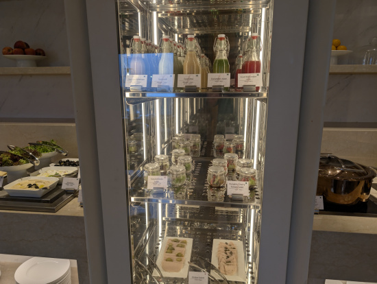 a glass case with bottles and food on it