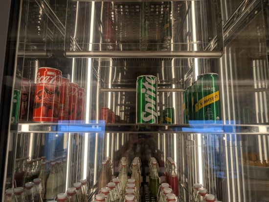 a display case with soda cans and bottles