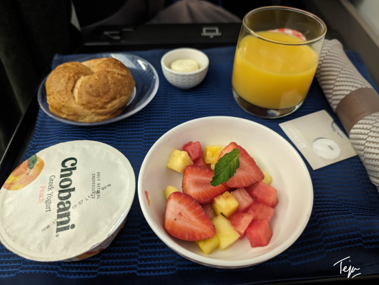 a plate of fruit and a glass of juice on a tray