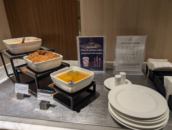 a buffet table with bowls of food and plates