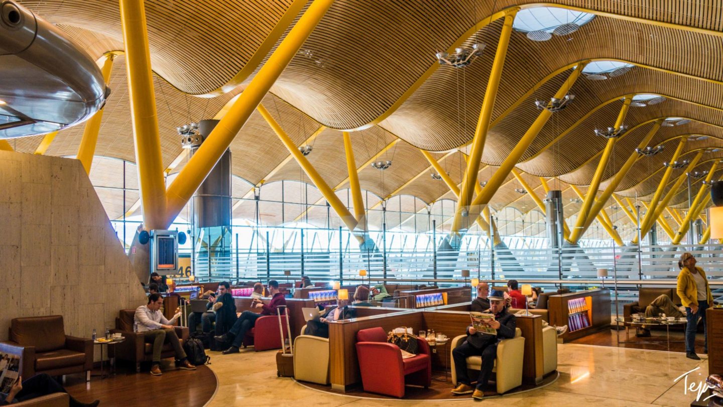 people sitting in a room with yellow beams and a large ceiling